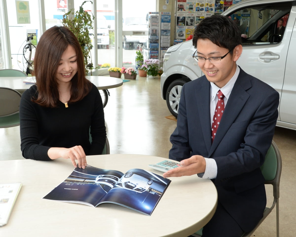 お客さんに車の資料を説明している写真